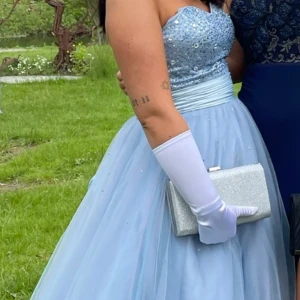 Balklänning  - Dags att sälja min balklänning. Jag köpte den för 5000kr. Den är lite smutsig längst ned men inget som man tänker på. Handskar, innekjol och väskan ingår samt hår accessoarer. Billigare vid snabb affär då jag flyttar och har inte plats. 