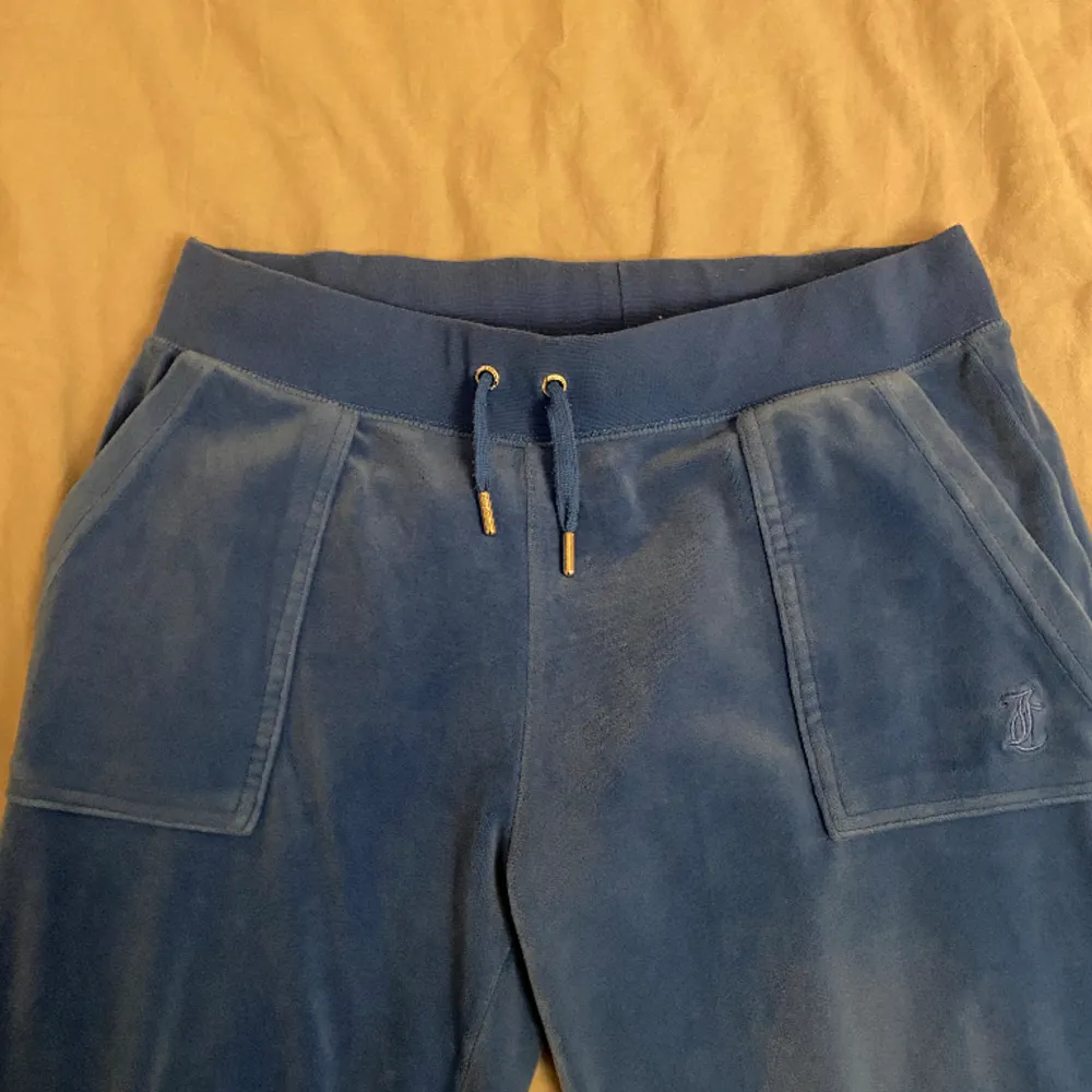 Säljer dessa blåa juicy byxor då de är lite för stora. De är rätt använda så de är lite bleka i färgen men är ändå i bra skick.. Jeans & Byxor.