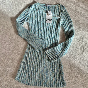 ZARA stickad asymmetrisk turkos miniklänning - Snygg stickad klänning från ZARA med asymmetrisk urringning vid bysten och knappar längs sidorna. Aldrig använd, ny med tags kvar.