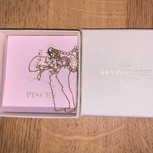 Lilly and rose star sign pisces (fiskarna) - Handgjord Material :gold plated brass Längd: 40-48cm Swarovski kristaller Original box Aldrig använt