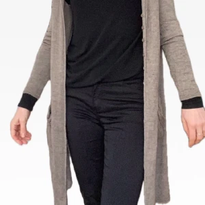 Lång tunn slank kofta Transit-par-such Stl M - Så fin kofta i främst silke och baby alpacka från lyx-märket Trasit Par Such. (Kostade 5000 kr)  Tunnstickad i elegant smal modell och passar såväl vinter som sommar. Vacker mulllvadsfärg.  Knappar fram och fickor.