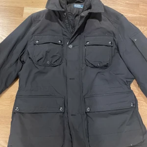 Field Jacket från Ralph Lauren - Säljer min field jacket från Ralph Lauren i storlek L, storleken sitter tts. Mycket funktionell jacka med många fickor utvändigt samt invändigt som passar perfekt för vinter och vår. Jackan är justerbar i midjan. Hör av dig vid ytterligare frågor! 