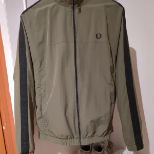 Helt oanvänd Fred Perry jacka - Jacka från Fred Perry. Köptes år 2022. Originalpris 1500. Storlek medium.  Jag ångrade mig när jag väl kom hem. Jackan har bara hängt på kroken. Helt och hållet oanvänd.