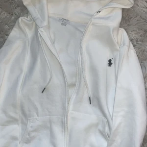 Polo zip vit - Hej! Säljer nu denna Raulph Lauren zip tröjan i vit.Svårt att se att detta är en 1:1kopia då den är i väldigt bra skick och tillkommer även med påse💞🙌🏼