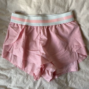 Träningsshorts - Träningsshorts från Stronger. Rosa med tightare innershorts och volang utanpå. Säljer då de var något stora på mig. 