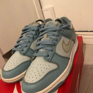 Nike dunk Low ’clear blue swoosh’ limited edition.  - Nike dunk Low ’clear blue swoosh’ limited edition.  Beskrivning: lite slitna under höger skon.  Nypris: 2099kr’ jag säljer dem för 550kr 600kr med creaseskydd:) OBS PRIS kan diskuteras. 