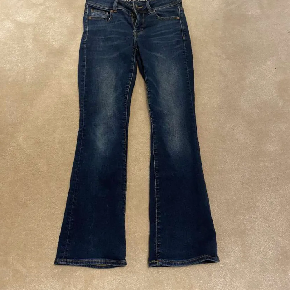 Snygga mörkblå jeans från American Eagle med coola fickor! Innerbenslängd:72 midjemått:38💕 Skriv för mer info!💕. Jeans & Byxor.