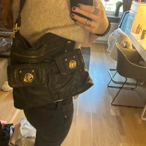 Handväska - Snygg handväska som ej kommer till användning. Den har guld detaljer och mycket fack i väskan 