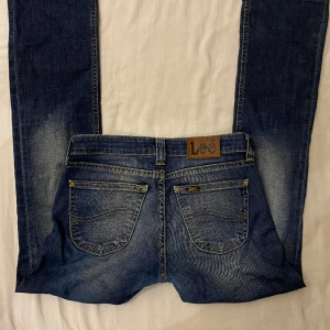 Lågmidjade Lee jeans - I väldigt fint skick, skulle säga att dom är som en blandning mellan raka och bootcut jeans, har inte super mycket svängning längst ner men det ser fortfarande ut som bootcut på (sista bild) Mått: innerbenslängd 72-73cm, midjemått rakt över ca 37cm💕 
