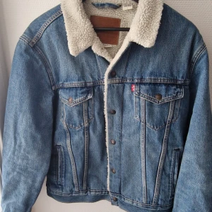 Levis sherpa trucker jacka  - Mint condition levis trucker jacka mellan blå färg inköpt 2020 men har inte haft använding för den så passar perfekt å rensa garderoben 