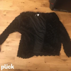 Svart pälskofta  - Säljer denna koftan då d itne används elr! Väldigt trendig!