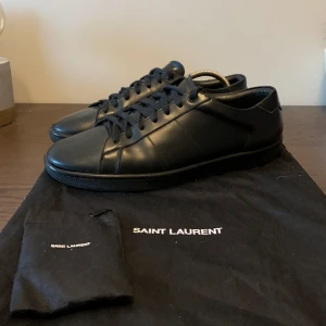 Saint Laurent Skor - SJUK STEAL! Helsvarta Yves Saint Laurent Skor i riktigt fint skick! Vid köp ingår originaldustbag och en till mindre dustbag med extra originela skosnören i. Normala i storlek (True to size).