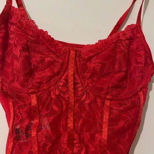 Röd spetsbody - Röd spetsbody som är aldrig använd. Väldigt snygg!