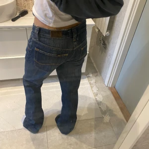 Supersnygga mörblåa lågmidjade utsvängda jeans - Mörkblåa jeans från Lee. Supersnygga som tyvärr är för långa för mig. Det står ingen storlek men skulle kunna säga W30 och L34. Är utsvängda och i bra skick. Använda 3 gånger sen köpet.