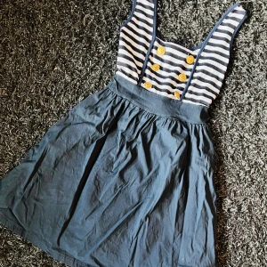 Marintema sommarklänning - Jättefin klänning med marinttema. Blå och vit randig med knappar där fram.