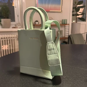 Axel arigato väska  - En väska från Axel arigato. Använd 2 gånger. Medföljer ett långt band. 