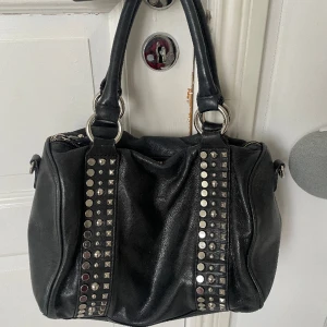 Svart väska med nitar - Svart väska med nitar, medföljer förlängningsband. 