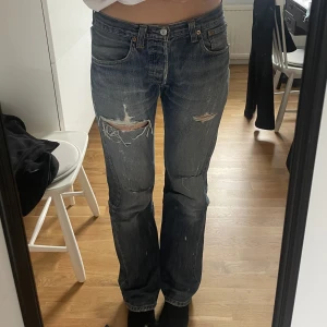Vintage Levis 501 - Vintage 501 Levis jeans men slitningar och hål. Super fina och sitter väldigt bra på mig som är 180 cm, större i midjan dock så lite loose fit. Lite sliten lapp där bak(de sista bilden) men annars bra skick.