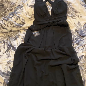 Svart lång klänning  - Svart lång klänning, väldigt fin  Perfekt för en skol bal eller liknande event  Aldrig använt, lappar sitter kvar på klänningen Strl 46