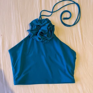 Blue top with flower accent  - Worn only once , still in good condition 