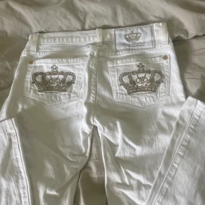 Victoria Beckham jeans  - Säljer ett par jätte fina lowaist Victoria Beckham jeans! Pga att det är för små i längden för mig. De är i st 24 och passar perfekt i midjan men de är för korta på mig som är 165 cm. De är vita med guld kronor. Rakt över 34cm och innerben 70 cm