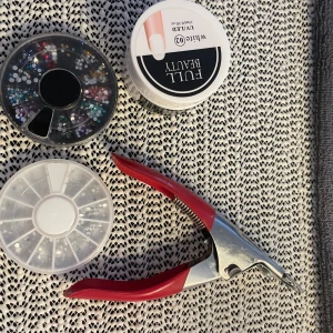 Nagel saker - 1 vit gel helt oöppnad 1 nagelsax 2 förpackningar med stenar, en är vanliga ”diamanter”, andra är med massa olika färger. Lila, blå, mörkblå, röd, gul, rosa och mörkgrön. Priset är satt för köp av allt, går inte köpa styck