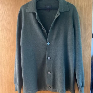 Mörkgrön stickad skjorta - Jag säljer min otroligt sällsynta och unika stickade mörkgröna skjorta från Less Worries som är perfekt att ha som sommarplagg och väldigt fin. Den är i tunnt stickat material och fint stickad och pris kan diskuteras vid snabb affär.