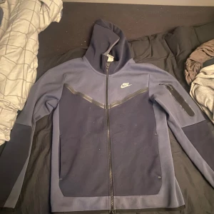 nike tech - Den är i nästan nytt skick och är bara andvänd ett fåtal gånger Om du är intresserad av hela dressen så har jag den och då kan du få både tröjan och byxorna för 800kr Jag säljer den för att den var för stor för mig  