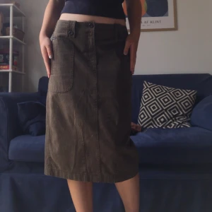 Kjol - Midi kjol som är brun storlek 40. Går nedanför knäna på mig som är 172cm. Bra kvalitet och skön. Lite 90-tal