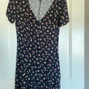Söt sommarklänning - Söt. Sparsamt använd. Svart med små blommor.  Liten volang längst ner. Går strax ovanför knäna på mig som är 172cm. Viskos.