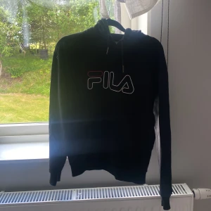 Svart Fila hoodie - En svart hoodie från fila, då den inte kommer till användning längre! Använd ett par ggr, i storlek xs! Med luva. 💖 Vet inte hur mycket jag köpte den för men 80-100:- hade ja kunnat tänka mig!