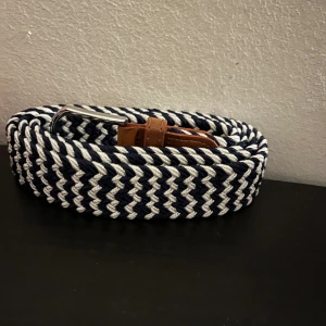 Flätat bälte - Ett blåvitt flätat bälte helt oanvänt 