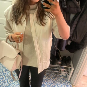 Vit bomberjacka väst - Superfint skick, jättefin silkes~känsla på materialet. Inte kritvit utan mer krämvit. Det står L i strl men passar lite snyggt oversize på mig som brukar ha S! Passar perfa till våren!!💐