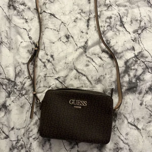 Säljer en jättefin guess väska helt oanvänd för 800 kr, köpt för 900kr. Köparen står för frakten - En helt oanvänd unik och stilren väska från märket Guess!⭐️ Köparen står för frakten 