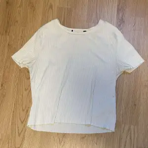 En vit t-shirt. Tjockare tyg än en vanlig t-shirt.