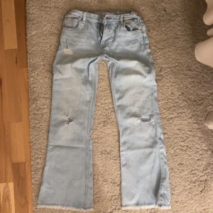 Lågmidjade håliga jeans  - Säljer dessa ljusblåa lågmidjade jeans med hål i sig som är modellen. Dessa är ifrån zara och säljer de pga att de är för korta för mig som är 170 cm drygt, så passar någon runt 165cm. Helt nya! Kontakta via intresse eller köp🥳pris kan diskuteras 