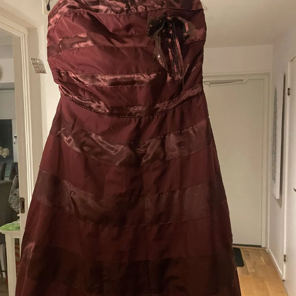 En vinröd balklänning Köpt i kanada med under kjol och rosset storlek 38. Klänningar.