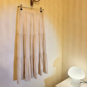 Beige kjol Gina Tricot - Bella Skirt från Gina Tricot storlek XS. Beige vadlång kjol med innerkjol -ej genomskinlig. Mycket fint skick!