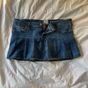 Volangkjol - Lågmidjad blå volangkjol från Lee som jag har sytt från ett par byxor. Kan inte hitta storlek men skulle säga S och det är 40 cm tvärs över midjan. Fickorna är inte kapade/ihoppsydda! Använd gärna köp nu!