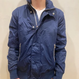 Jacka Bommerang - Jacka Boomerang  Modell: 184cm & väger 84kg  Skick: allmänt använd,  Färg: blå Material: polyester 