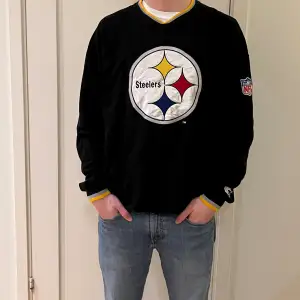 En svart Steelers sweatshirt i storlek XL. Kvaliten är bra och det finns en NFL logga inuti tröjan.