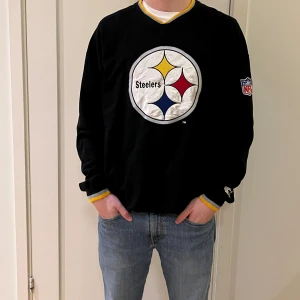 Steelers sweatshirt  - En svart Steelers sweatshirt i storlek XL. Kvaliten är bra och det finns en NFL logga inuti tröjan.