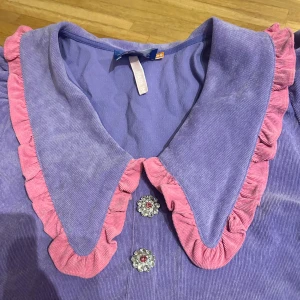 Blus - Manchester lila blus och ljusrosavolang runt kragen med fina knappar helt ny