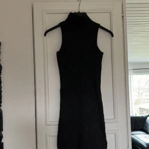 Klänning - Ribbstickad mörkgrå klänning strl XS. Lappen i nacken lossnat på ena sidan. Använd i fint skick. Katt och hund finns i hemmet.