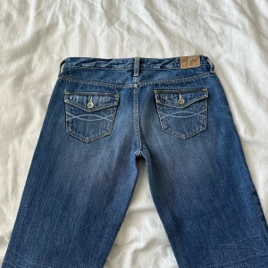 Lågmidjade bootcut jeans  - Vintage från Abercrombie & Fitch 🩷så fina!! Försmå kan en visa på. Midja: 74cm o innerben: 82cm 