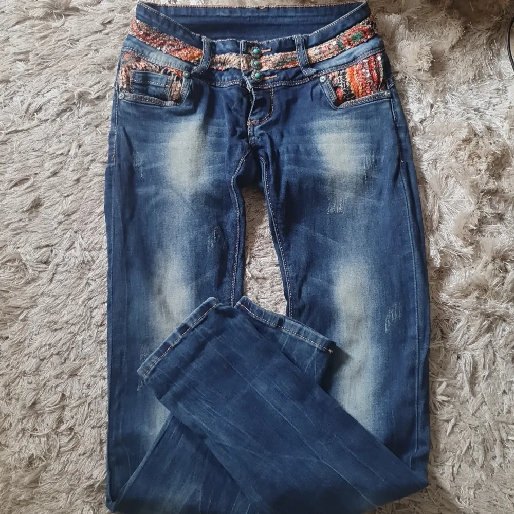 Jeans som är ovanliga  med massa detaljer..massa paljetter både fram och bak snygga knappar låg midjande ..fickor fram bak snygga slitningar storlek 26 passar xs s väldigt fint skick!. Jeans & Byxor.