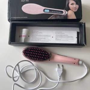 Rosa HQT-906 hårborste plattång - Säljer en rosa HQT-906 hårborste plattång. Den har en digital display som visar temperaturen och en lång sladd med EU-kontakt. Borsten har svarta och röda piggar och är designad för att snabbt och enkelt platta håret. Perfekt för daglig användning och styling, saknas en röd plupp!
