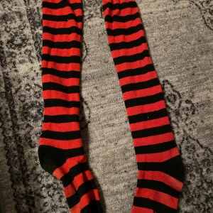 Thighhighs - röda Thighhighs, fick av en kompis 2021 ett litet hål längst ner vid ankeln, annars i bra skick, välanvända Ett tjockt skönt material, lite noppriga, går ovanför knäna