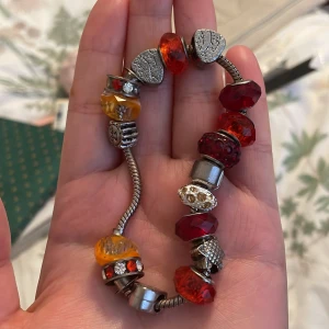 Färgglatt armband med pärlor och hjärtan - Säljer ett superfint armband med en mix av färgglada pärlor och hjärtan. Armbandet har en silverfärgad kedja och pärlor i rött, orange och gult. Perfekt för att liva upp vilken outfit som helst! 💛armbandet är från Pandora men är osäker på priset då det är en gåva. 