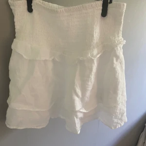 Vit volangkjol från GinaTricot Young  - En jättesöt volangkjol från Ginatricot Young i storlek 158/164. Den är bara använd ett fåtal gånger och i ett jättefint skick.